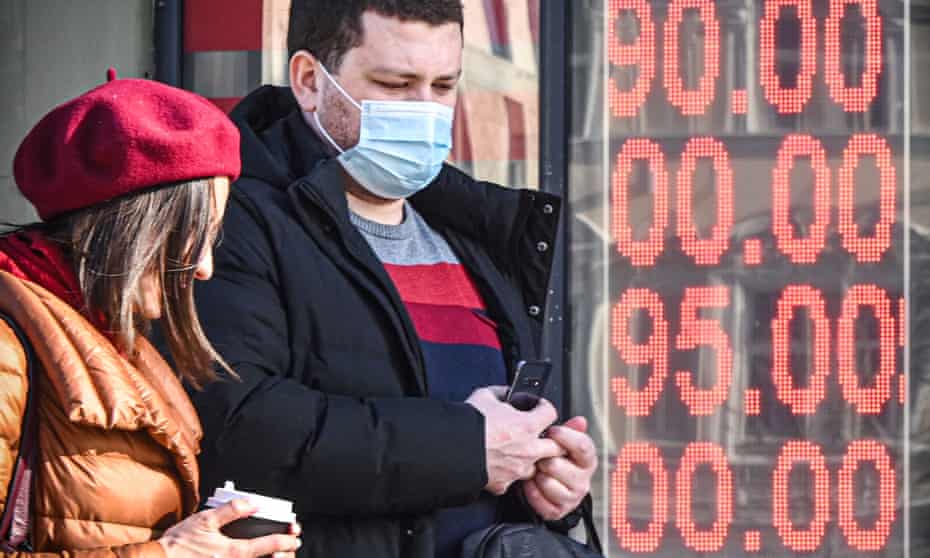 People walk past a currency exchange office in central Moscow on February 28, 2022, with zeros on the scoreboard since there are no three-digit sections on it to display the current exchange rate. 