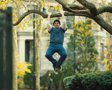 Anthony Ippolito, as a young Stallone, hangs from a tree branch in a park scene