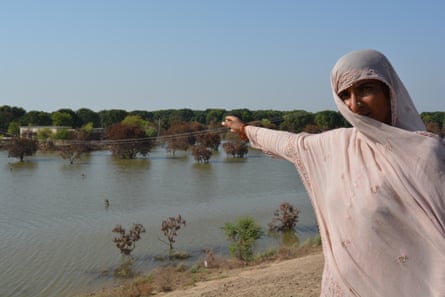 Rubina Nawaz points to where her home lies submerged in flood water.
