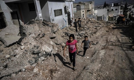 Palestinian children walk along a road ripped up by an Israeli bulldozer in the Jenin refugee campin the West Bank. 
