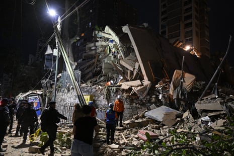 Rescuers search through the rubble of a collapsed building in Caracas