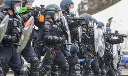 Riot police on guard at the bottom of Westgate Bridge as thousands march through Melbourne