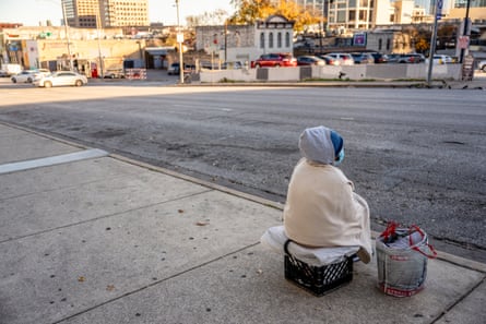 a person sits on a sidewalk