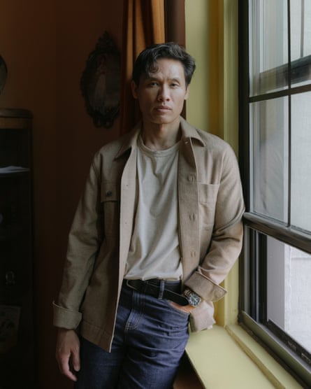 A man poses next to an open window