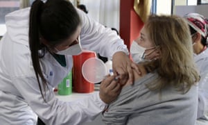 A woman gets her shot of the Covid-19 vaccine, in Quito, Ecuador, 23 December as the government of Ecuador declares Covid vaccination mandatory.