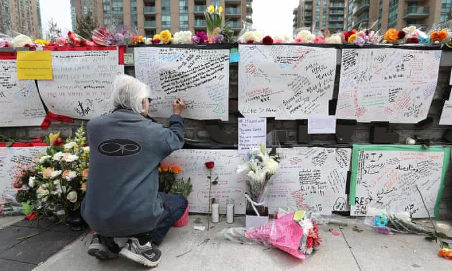 A man leaves a note at a makeshift memorial for the victims of the van attack in Toronto on 24 April 2018.