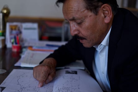 A middle-aged Indian man pointing to a map of the Indian-Chinese border region in Ladakh