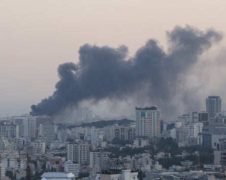 Smoke billowing above city rooftops
