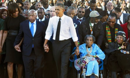 In this 7 March 2015 file photo, President Barack Obama holds hands with Representative John Lewis and Amelia Boynton Robinson as they walk across the Edmund Pettus Bridge in Selma, Alabama, for the 50th anniversary of Bloody Sunday.