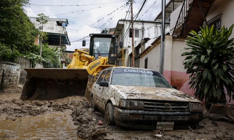 A car is buried in the mud after heavy rain hits Macarao parish in Caracas, Venezuela.