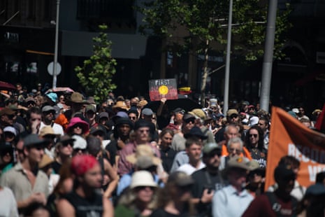 People hold signs during an Invasion Day rally in Melbourne
