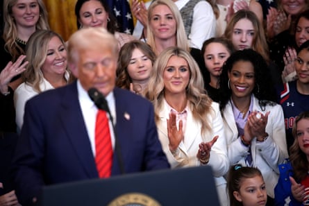 Political activist and former competitive swimmer Riley Gaines, center, appeared alongside Donald Trump in February as he signed an executive order banning trans girls and women from competing in women’s sports.