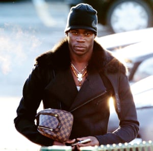 Bags of style: Mario Balotelli arrives at a training session in Manchester.