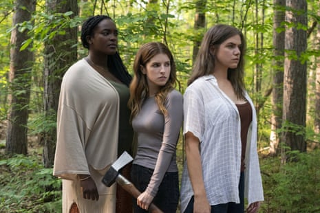 Three women stand in a forest, one with an axe, in a scene from Alice, Darling