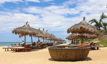 Sun loungers, bamboo shades and coracles on An Bang beach, Hoi An