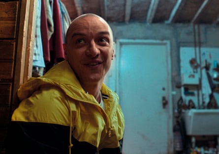 He stands in a grubby-looking room with a wild expression on his face