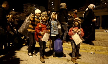 Refugee children disembark from a passenger ferry at Piraeus Port in Greece.