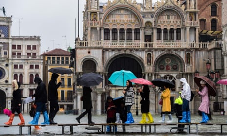 Visitors cross the flooded St Mark’s Square in Venice on a temporary footbridge during a high tide.
