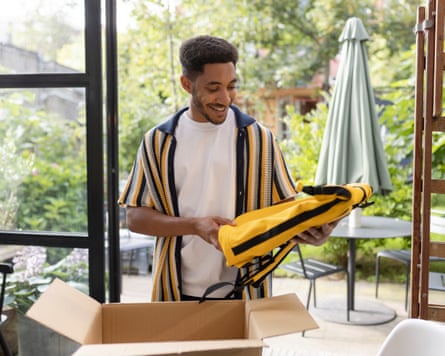A man taking clothing out of a box