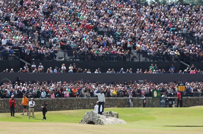 Tiger Woods acknowledges the crowd on the Swilcan Bridge on the 18th.