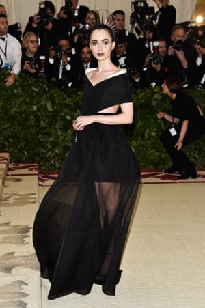 Lily Collins steered clear of the angelic look and went for something darker with her sheer Givenchy gown and Gothic make up, while clutching rosary beads.