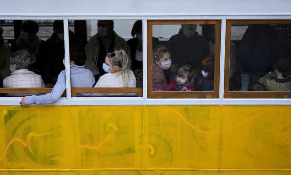 People wearing face masks ride the Gloria funicular in Lisbon.