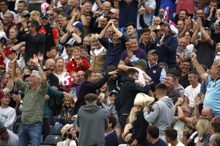 A spectator celebrates after catching a ball from England’s batsman Moeen Ali’s stroke shot.