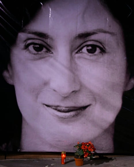 Daphne Caruana GaliziaFILE - Flowers and a candle lie in front of a portrait of slain investigative journalist Daphne Caruana Galizia during a vigil outside the law courts in Valletta, Malta, Oct. 16, 2018. (AP Photo/Jonathan Borg, File)