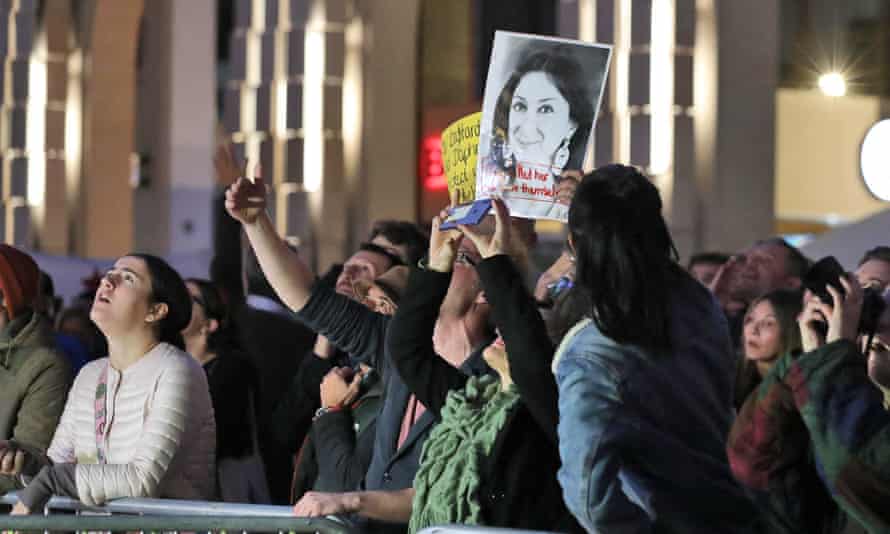 Demonstrators hold up an image of Daphne Caruana Galizia protest outside Malta’s parliament, in Valletta, on 26 November.