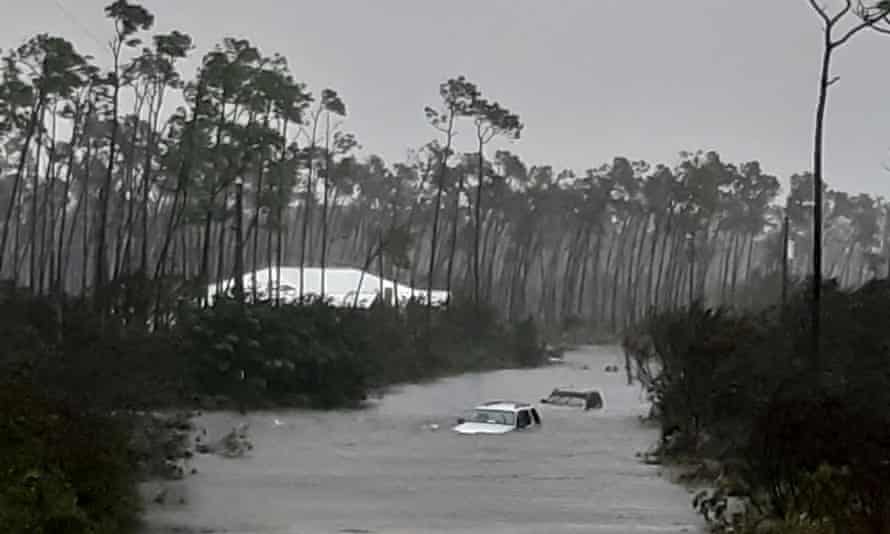 Rising waters cover cars on a road in Freeport on Tuesday.