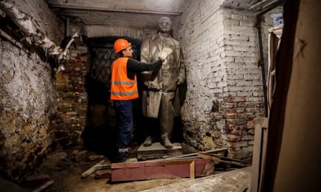 A worker cleans a sculpture of a historical figure in the destroyed local history museum in Mariupol.