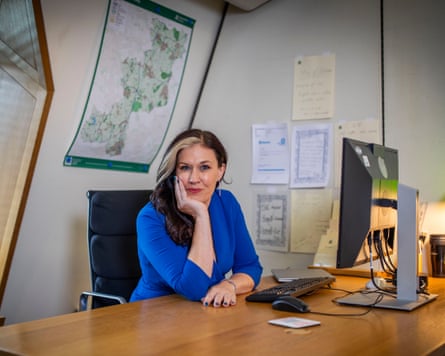 Natalie Flee at a desk in a blue dress
