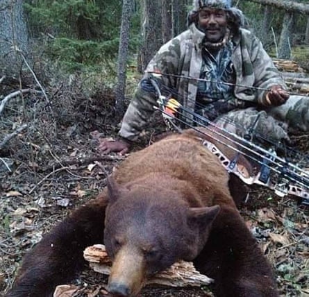 Former basketball star Karl Malone with a bear he killed with a bow