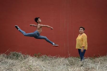 Young dancer Aaron de Jesus Marquez jumping near his grandmother