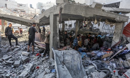 Palestinians inspect the damage after an Israeli strike hit a house belonging to a family in a refugee camp in Rafah