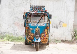 A blue tuk decorated with illustrations of people