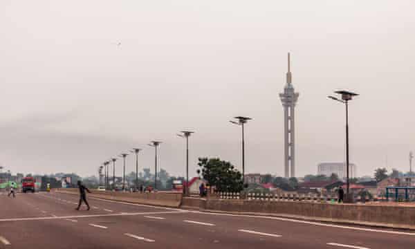 en tom avenue i Kinshasa med Limete tårnet i baggrunden.