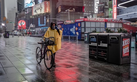 A lone person walks through Time Square in New York City on 29 March 2020.