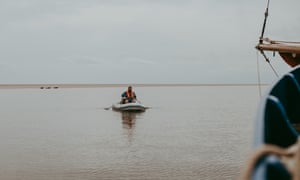 Chef Charlie Hodson takes food supplies and cooking utensils to the sandbank in a dinghy.