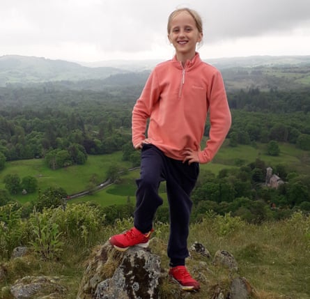 Young girl standing on a rock in the Lake District, UK
