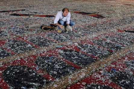 A man removes broken glass scattered on the carpet of a mosque damaged in Tuesday’s blast in Beirut, Lebanon August 5 2020.