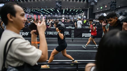 People carry weights on their back along marked out lanes