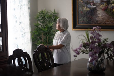 woman wearing white looks out window