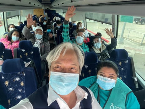 A selfie of Sister Norma with a bus full of migrants