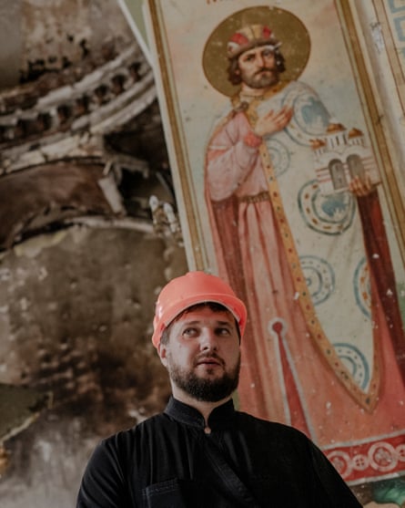 Priest stands in front of damaged interior