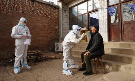 A medical worker collects nucleic acid sample for a villager at Shizhuang Village in Yuanshi County of Shijiazhuang City