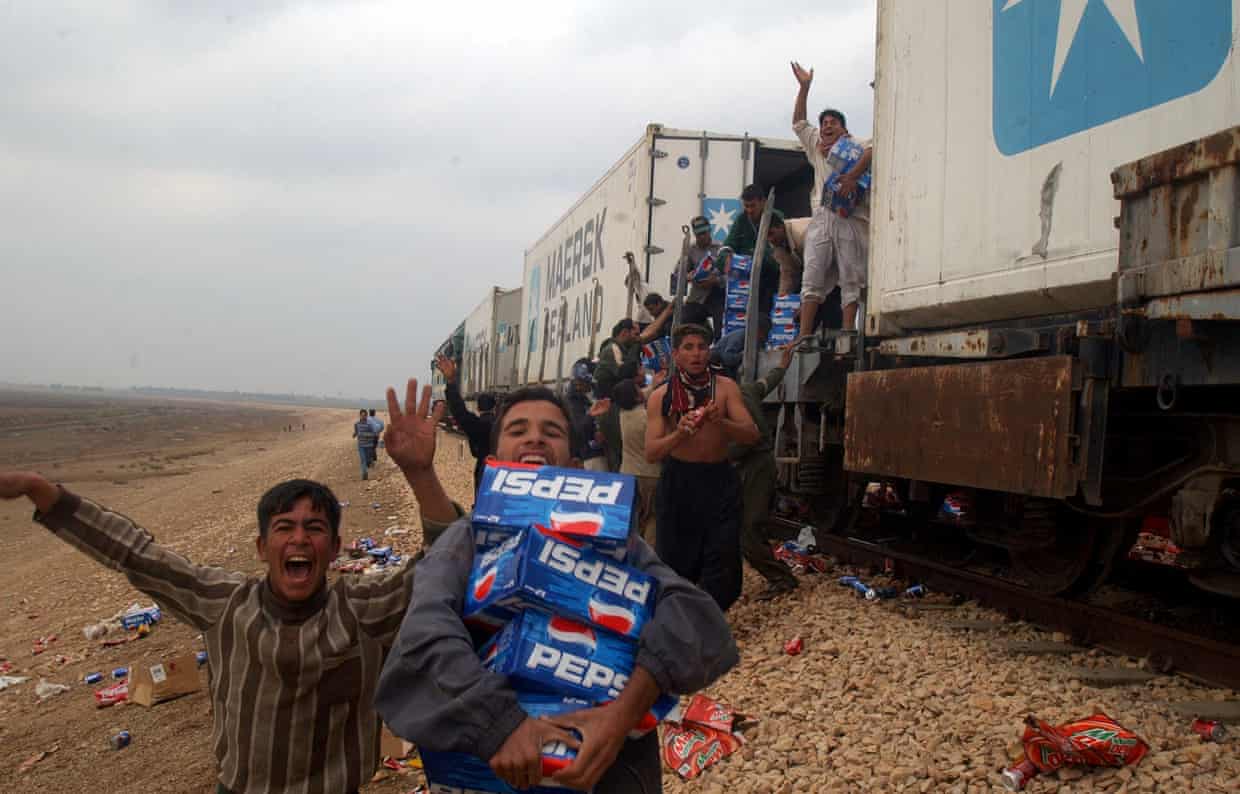 Iraqis loot a US army supply train near Falluja in December 2003. Photograph: Khalid Mohammed/AP