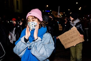 A woman covering her ears as she passes the Church of the Holy Cross, in Warsaw, where Catholic fundamentalists, flanked by nationalist militias and separated from protesters by police and military officers, were playing the cries of newborns through loudspeakers.