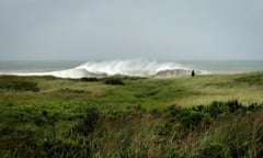 A person walks in the sand Dunes as heavy surf rolls onto the south shore of Martha's Vineyard island, as Tropical Storm Henri approaches the New England coast in West Tisbury, Massachusetts, U.S., August 22, 2021. John Segar via REUTERS THIS IMAGE HAS BEEN SUPPLIED BY A THIRD PARTY.