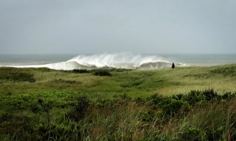 A person walks in the sand Dunes as heavy surf rolls onto the south shore of Martha's Vineyard island, as Tropical Storm Henri approaches the New England coast in West Tisbury, Massachusetts, U.S., August 22, 2021.